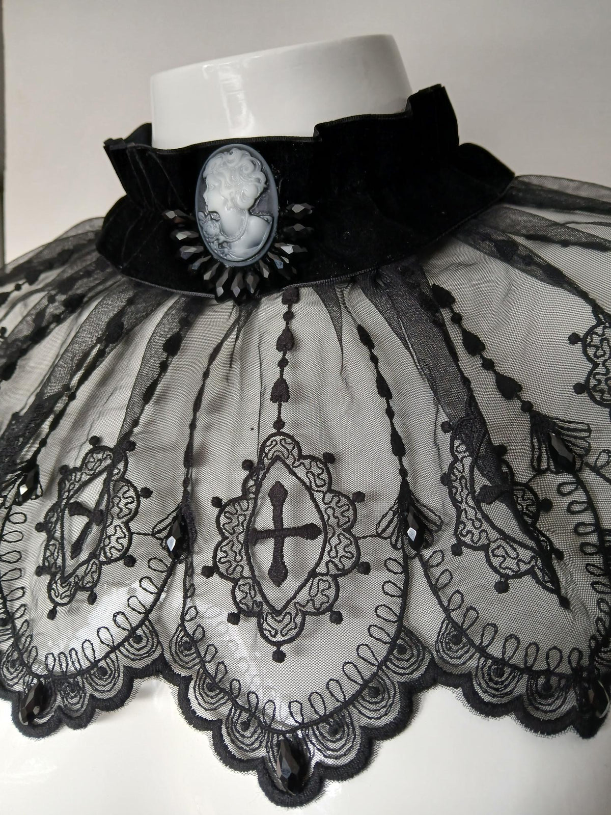 Detailed product photograph of the cameo, velvet neckband and embroidered black lace