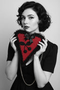 Pin-up model holding red crochet heart bag close to face, black lace ruffle trim, black satin bow, cherry appliqué, gold chain strap, dramatic winged eyeliner — Victorian Velvet