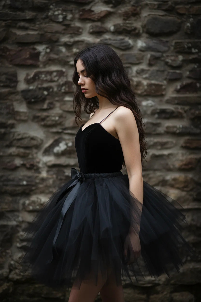 Black tulle tutu skirt with black satin ribbon bow at waist, worn with black velvet corset top, side view, gothic fashion editorial - Victorian Velvet