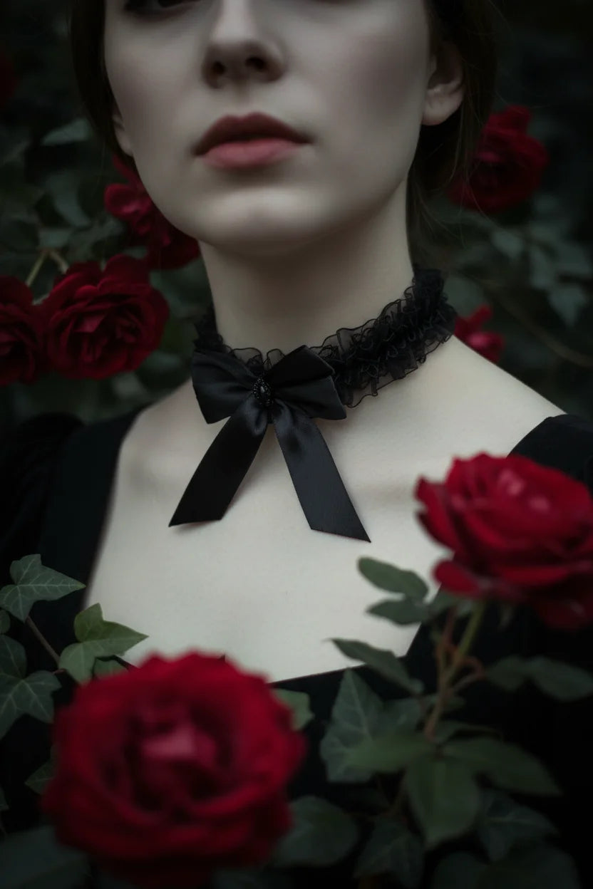 Black organza ruffle choker with satin bow, close-up on woman's neck surrounded by red roses, Victorian Velvet handmade gothic jewellery