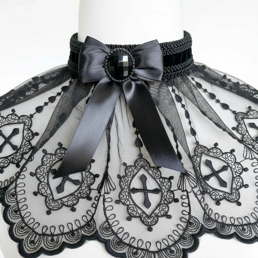 Close-up detail of gothic lace collar showing black satin bow, faceted black gemstone button and intricate cross embroidery on sheer tulle - Victorian Velvet
