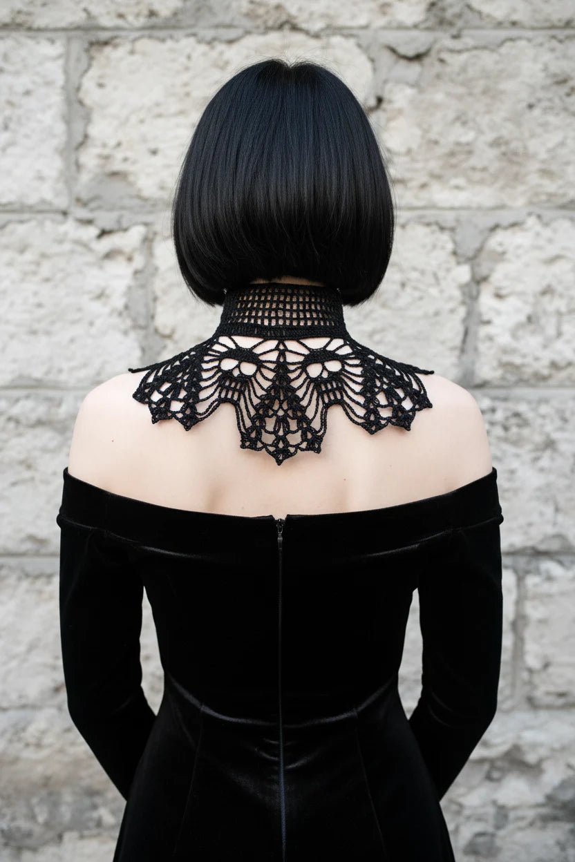 Back view of a pale gothic woman with short dark black bob hair with fringe wearing a black fine crochet lace collar with wide high turtleneck band with open square grid mesh pattern, wide dramatic wing-shaped lace crochet panels draping symmetrically over both shoulders with intricate gothic lace pattern and scalloped pointed tips forming a V shape at center back, worn over a black off-shoulder velvet dress, grey stone wall background - Victorian Velvet