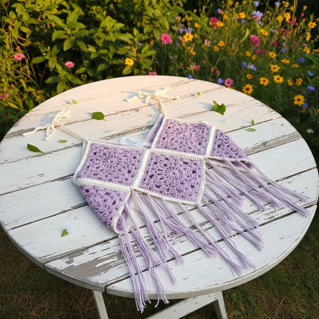 Lavender & White Granny Square Crochet Top - Boho Festival Fringe — flat lay on a rustic white wooden garden table outdoors, summer light with green leaves in the background - Victorian Velvet
