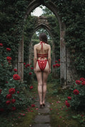 Handmade crimson red crochet lingerie set with single red satin bow, back view, gothic garden ruins with red roses, romantic dark atmosphere - Victorian Velvet