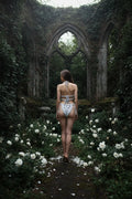 Handmade silver grey crochet lingerie set with silver satin bows, back view on model, romantic gothic garden ruins with white roses and ivy arch - Victorian Velvet