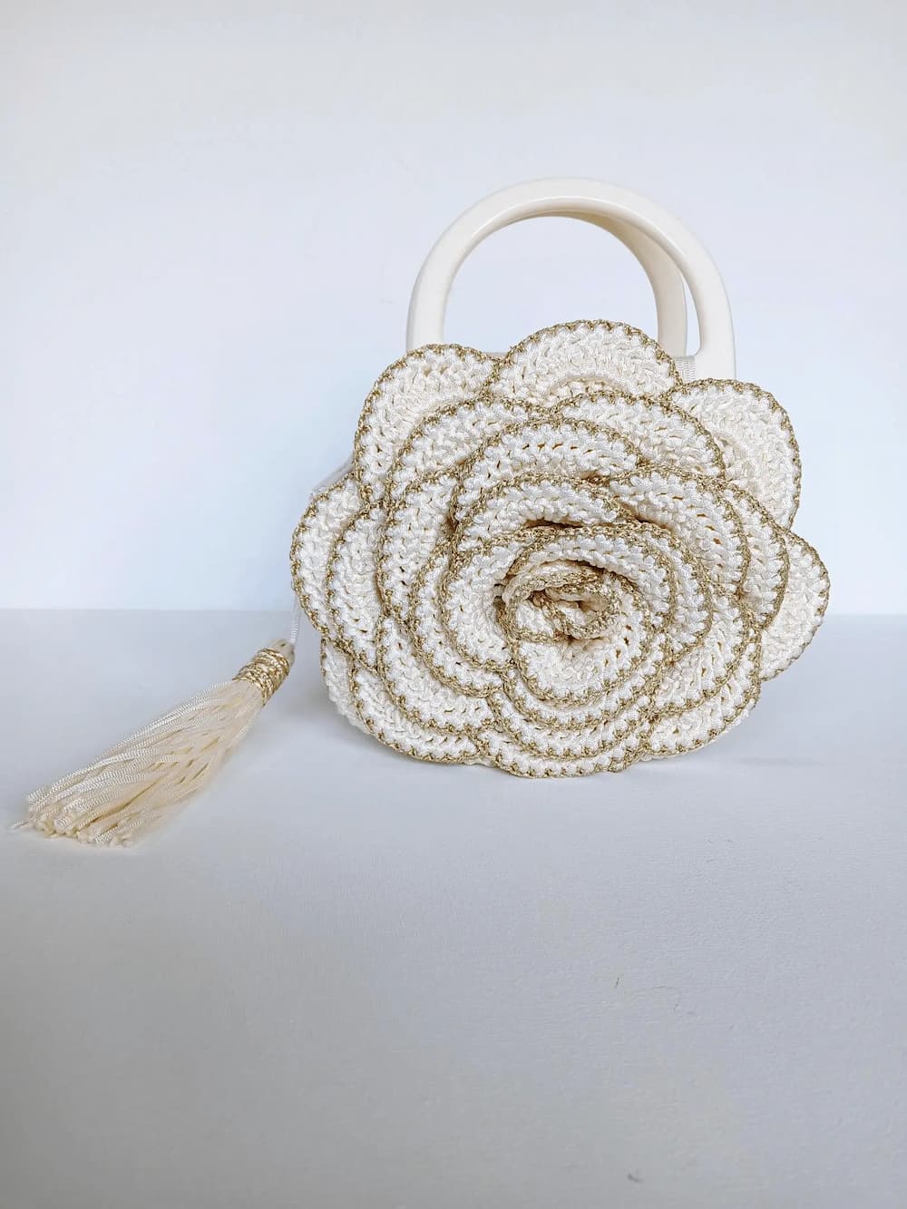 Versailles Rose handmade crochet rose handbag front view — cream and gold metallic yarn, ivory handles, cream tassel — Victorian Velvet