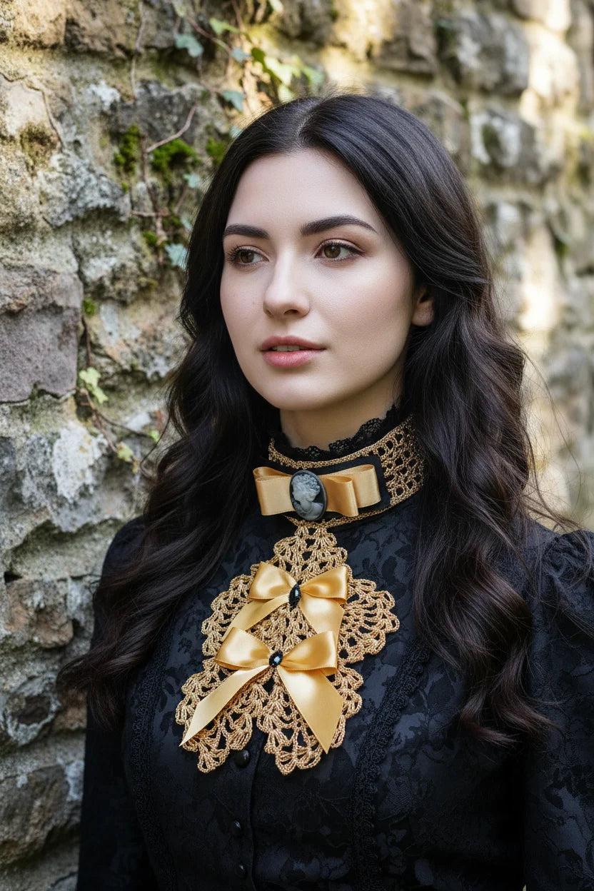 Handmade gold crochet jabot with gold satin bows and grey cameo brooch on black velvet choker, worn over a black Victorian high neck blouse, close-up portrait - Victorian Velvet