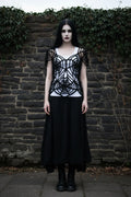 Gothic Spider Web Crochet Top full body front view – pale gothic model with long dark hair in black spider web top over white tank top and long black skirt, stone wall background - Victorian Velvet