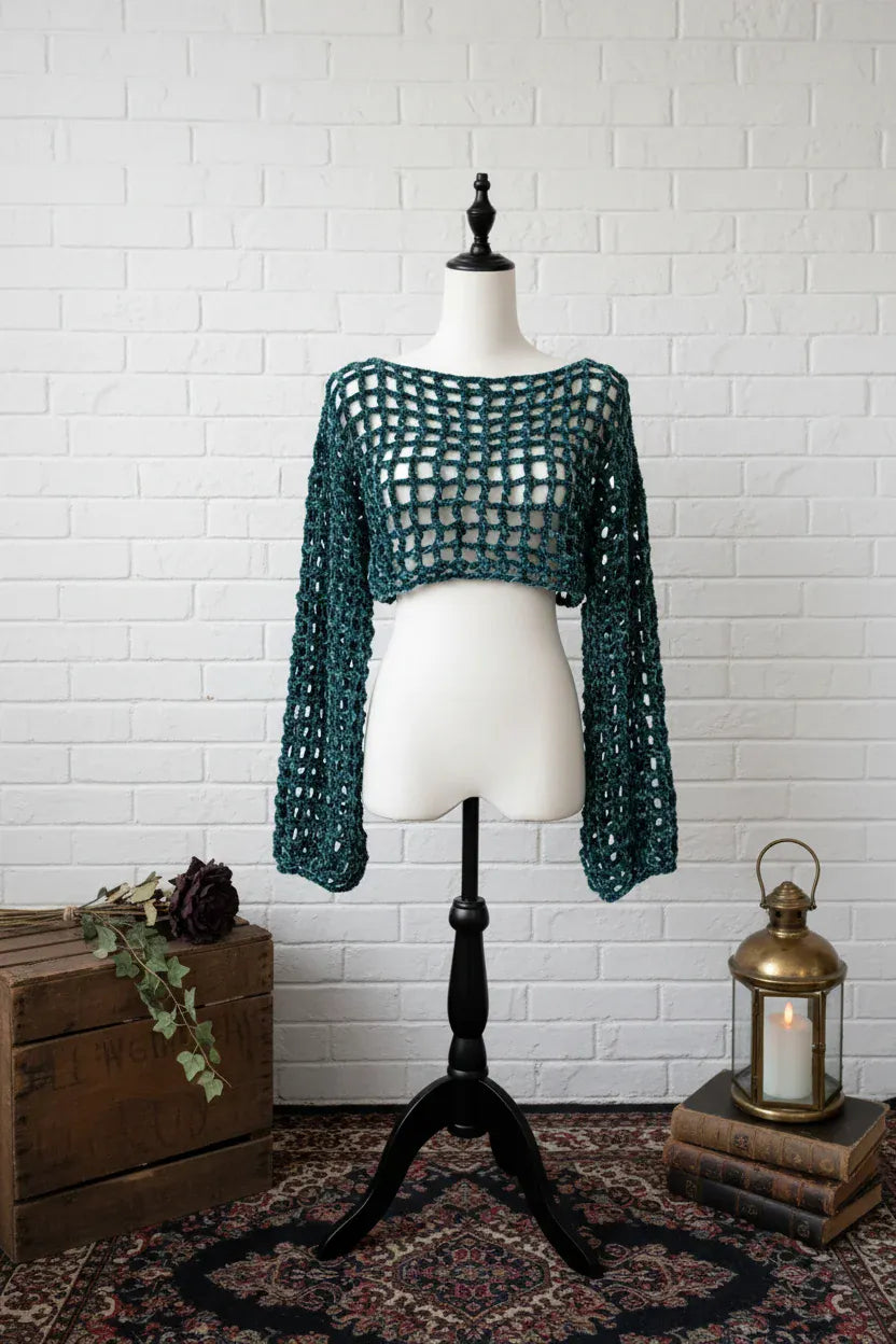 Forest green velvet crochet mesh sweater displayed on a mannequin with gothic lantern and dried roses
- Victorian Velvet