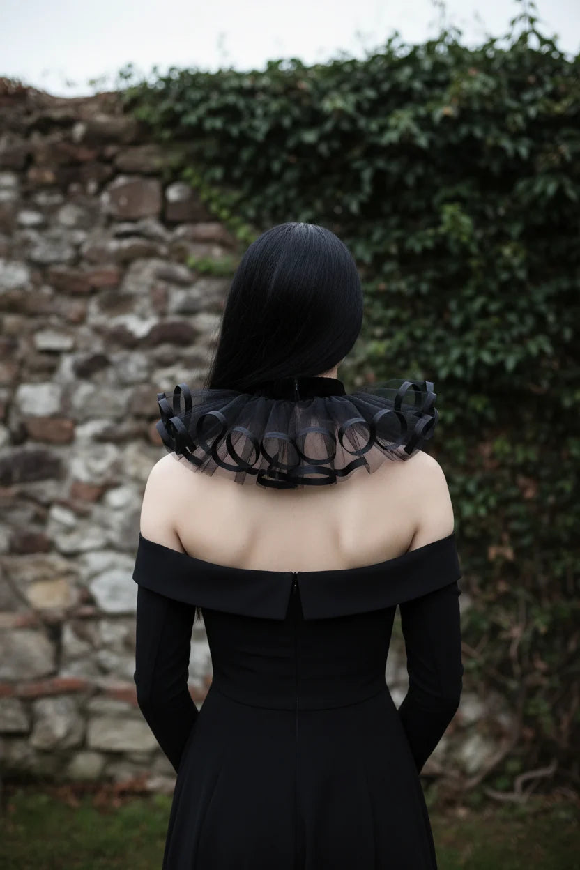 Back view of The Shadow Bloom gothic tulle collar with black velvet neckband, no closure at back, worn by a pale woman with long black hair, standing against an ivy-covered stone wall — Victorian Velvet