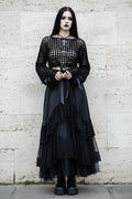 Black velour grid crochet crop top with long sleeves and satin bow ties at waist, worn with long black tulle skirt, gothic model with dark makeup and cross necklace, stone wall background - Victorian Velvet
